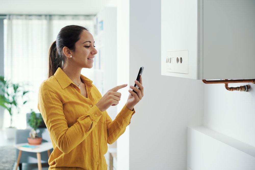 A woman pointing at a phone, ready to contact a trusted HVAC Contractor North Attleboro for expert service.