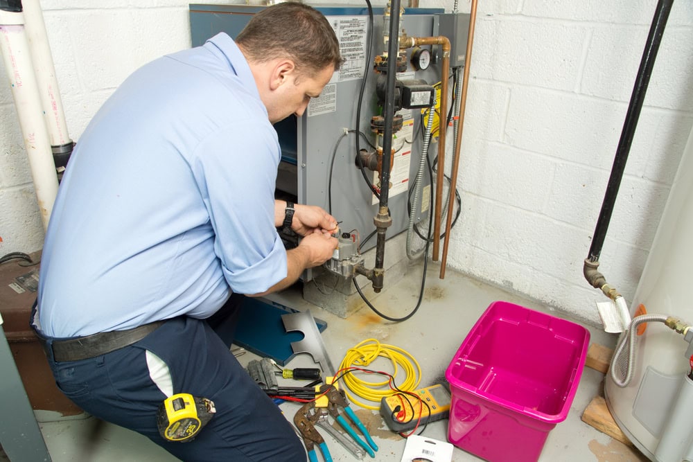Plumber from Dempsey Energy repairing a gas furnace in North Attleboro, MA, ensuring safe operation, checking connections, and performing maintenance for reliable heating in a residential home