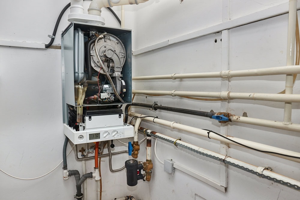 Boiler and interconnected pipes of a home heating system in North Attleboro, MA, showcasing Dempsey Energy’s professional installation and efficient residential heating setup